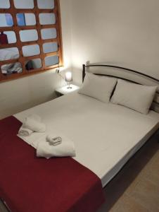 una camera da letto con un letto grande con asciugamani sopra di Sand house 2 a Néa Péramos