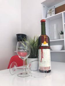 a bottle of wine sitting next to a wine glass at Apartments Endji I in Čilipi