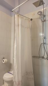 La salle de bains est pourvue d'un rideau de douche et de toilettes. dans l'établissement To Kastro, à Pylos