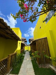 a walkway between two buildings with yellow at Villa Suites Gostoso - Condomínio Beira-mar in São Miguel do Gostoso