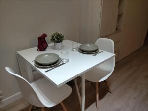 a white table with two plates and glasses on it at Home Sweet Home Mercaderes in Pamplona