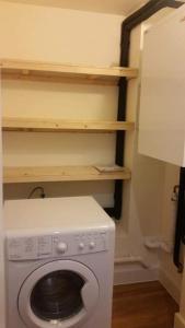 a laundry room with a washing machine and shelves at 1 bedroom apartment in London