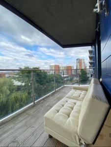 a living room with a couch on a balcony at 1 bedroom apartment in London