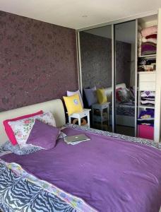 a bedroom with a purple bed with a book on it at 1 bedroom apartment in London