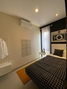 um quarto com uma cama em preto e branco e uma janela em Villa Canyata em Pasuruan