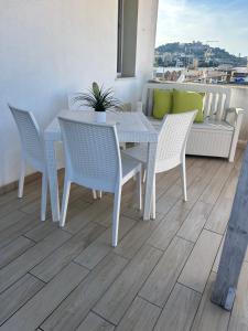 un tavolo bianco da pranzo e sedie sul balcone di Appartamento confortevole a Cagliari