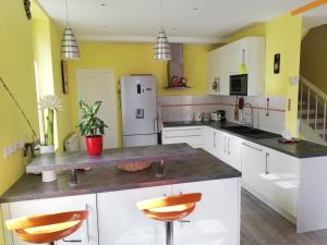 cocina con paredes amarillas y nevera blanca en Sauna dans Maison de maître proche Etretat -étage2, 