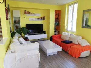 sala de estar con 2 sofás blancos y TV en Sauna dans Maison de maître proche Etretat -étage2 