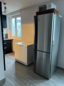 eine Küche mit einem Kühlschrank aus Edelstahl und einer Theke in der Unterkunft Appartement près de La défense in Nanterre