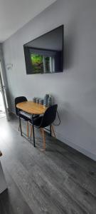 mesa con 2 sillas y TV en la pared en River side, en Dingle
