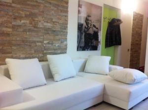 sala de estar con sofá blanco y 2 almohadas en Is Pardinas, en SantʼAndrea