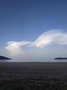 un grande campo aperto con cielo e acqua nuvolosi di Sand house 2 a Néa Péramos 1 altra foto