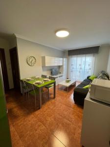 a kitchen and a living room with a table and a couch at Apartamento Marichu in Melide