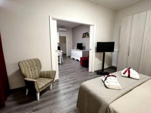 una habitación de hotel con 2 camas y una silla en Le Dimore di Luciana - suites & apartments, en Lecce