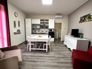 ein Wohnzimmer mit einem weißen Tisch und eine Küche in der Unterkunft Le Dimore di Luciana - suites & apartments in Lecce
