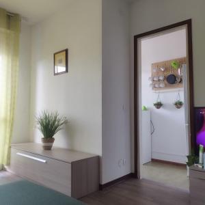 a living room with a mirror and a refrigerator at Mini apartment close to everything you will need in Pasian di Prato