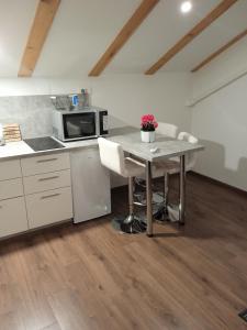 a kitchen with a table with chairs and a microwave at Studio appMZ in Krk