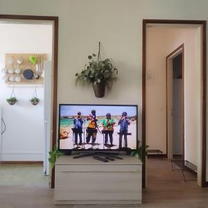 telewizor z płaskim ekranem siedzący na komodzie w obiekcie Mini apartment close to everything you will need w mieście Pasian di Prato