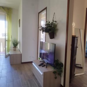 a living room with a flat screen tv on a cabinet at Mini apartment close to everything you will need in Pasian di Prato