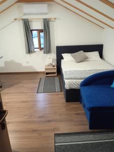 1 dormitorio con 1 cama y 1 sofá azul en Studio appMZ en Krk