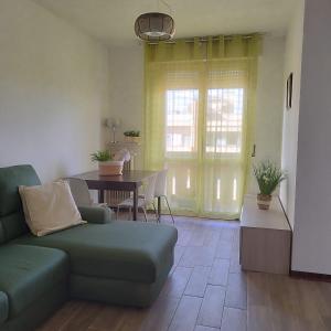 salon z kanapą i stołem w obiekcie Mini apartment close to everything you will need w mieście Pasian di Prato