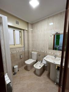 a bathroom with a toilet and a sink at Apartamento Marichu in Melide