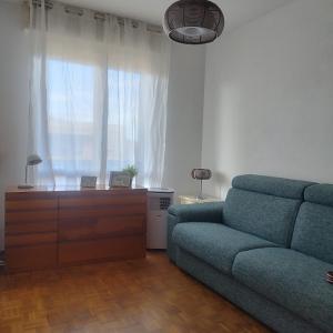 sala de estar con sofá, tocador y ventana en Mini apartment close to everything you will need, en Pasian di Prato