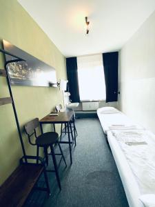 um quarto de hotel com uma cama, uma mesa e cadeiras em Hotel Schwarzer Bär em Hanôver