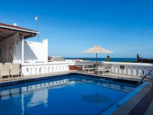 a swimming pool with a view of the ocean at Maru Maru Hotel in Zanzibar City