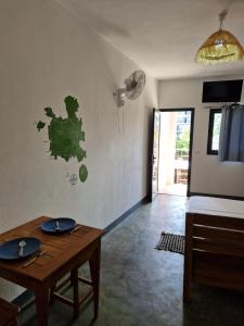 een woonkamer met een tafel en een ventilator bij Hôtel de la plage in Ambatoloaka