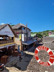 een man die in een straat naast een gebouw loopt bij Hôtel de la plage in Ambatoloaka