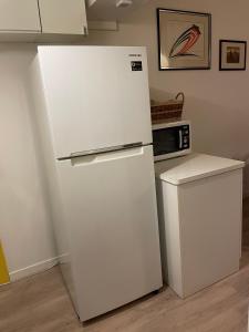 een witte koelkast in een keuken met een magnetron bij Alhambra Sweet Home near the Sea in Duna Verde