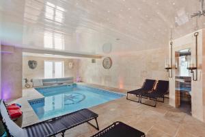 a large swimming pool with chairs and a couch at 5 Star Lux Coastal Gem - Indoor Heated Pool - Pets in Filey