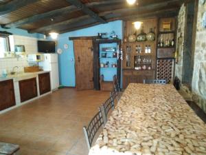 a kitchen with a large table with chairs and a kitchen with a refrigerator at Casa vacacional o trisquel in Pontevedra
