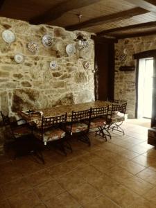 a room with a stone wall with a table and chairs at Casa vacacional o trisquel in Pontevedra
