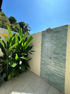 eine Dusche in einer Wand mit einer Pflanze daneben in der Unterkunft Villa Meranti - Spacious Private Pool Villa in Pantai Cenang
