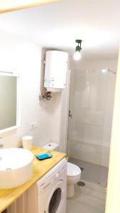 een badkamer met een wastafel en een wasmachine bij Holiday rent Fuerteventura in Costa de Antigua