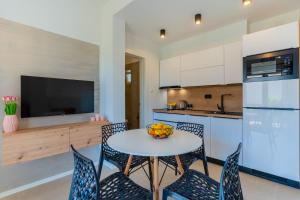 a kitchen with a table and chairs and a television at Apartments Ivanka Cres in Cres