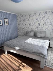 a bedroom with a bed in a room with wallpaper at Ferienhaus/Bungalow Lobbe - 60qm in Lobbe