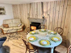 uma sala de jantar com uma mesa e uma lareira em gîte des hirondelles em Aromas