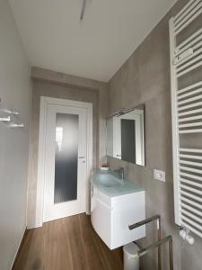 bagno con lavandino e specchio di Settimo Cielo Apartment Aosta CIR 0199 ad Aosta