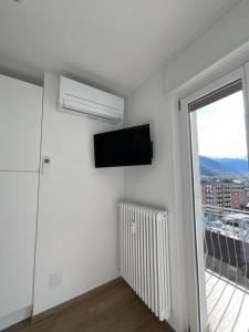 a white room with a flat screen tv and a window at Settimo Cielo Apartment Aosta CIR 0199 in Aosta