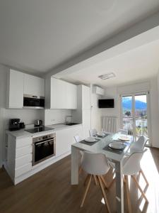 a white kitchen with a white table and chairs at Settimo Cielo Apartment Aosta CIR 0199 in Aosta