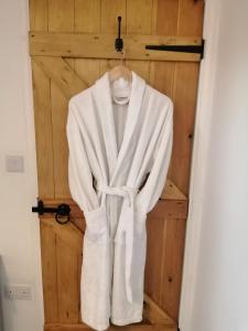 a robe hanging in front of a wooden door at Lake District and Eden Valley Thornhill Lodge in Long Marton
