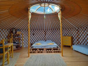 una camera con letto a baldacchino in una yurta di YOURTI MOUNTAIN EOOD a Plana