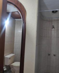 La salle de bains est pourvue de toilettes blanches et d'un miroir. dans l'établissement Flying House Hostel, à Arequipa