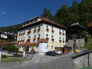 a large white building with cars parked in front of it at Hotel Kirchenwirt in Bad Kleinkirchheim