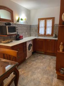 eine Küche mit einer Waschmaschine und einer Mikrowelle in der Unterkunft Beautiful apartment in Tossa de Mar in Tossa de Mar