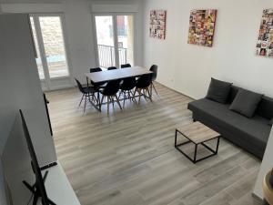 uma sala de estar com um sofá, uma mesa e cadeiras em Maison de village à 15min de la mer em Boujan-sur-Libron