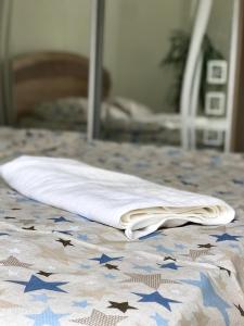 toalla blanca sentada en una cama frente a un espejo en 2-х кімн квартира в новобудові, en Ternopilʼ